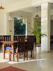 a dining room with a wooden table and chairs at Hardev Residency in Pathyar