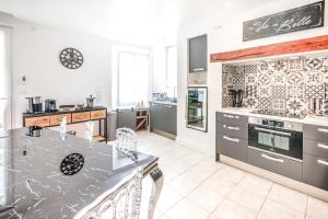 a kitchen with a counter and a stove top oven at Chez Louis le Tonnelier, Sauna et espace détente privés in Le Mesnil-sur-Oger