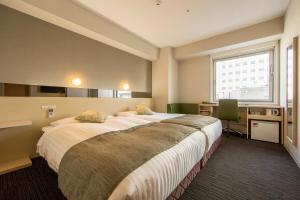 Postel nebo postele na pokoji v ubytování Super Hotel Premier Osaka Honmachi Ekimae Natural Hot Springs