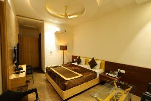 巴雷利Hotel Darbar-E-Khas的一间配有大床和桌子的酒店房间