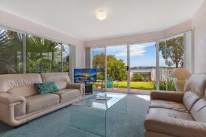 Una sala de estar con un sofá y un televisor. en Beach Street Apartments, en Merimbula