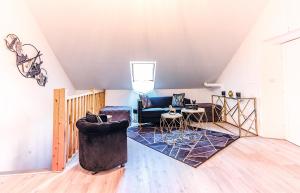 ein Wohnzimmer mit einer Couch und einem Sessel in der Unterkunft Gîte 4 étoiles avec sauna au coeur du vignoble - Louis le Tonnelier in Le Mesnil-sur-Oger