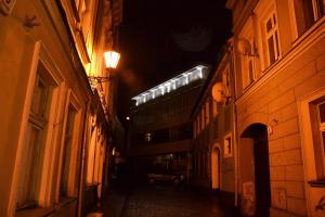 Une allée avec un bâtiment éclairé la nuit dans l'établissement Apartamenty Krawiecka, à Zielona Góra