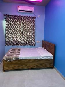 a bed in a room with a window with avertisement at Mangal Murti Family home stay in Alibaug
