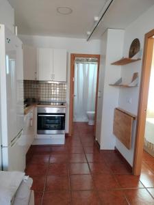 a kitchen with white cabinets and a tile floor at Playa Las Redes in El Puerto de Santa María +4 photos