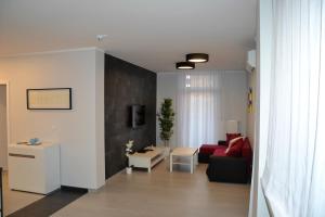 salon z czerwoną kanapą i stołem w obiekcie Apartamenty Krawiecka w Zielonej Górze
