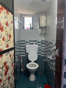 a bathroom with a white toilet in a room at Mangal Murti Family home stay in Alibaug +3 photos