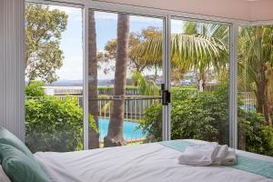 Un dormitorio con una cama y vistas a una piscina. en Beach Street Apartments, en Merimbula 27 fotos más