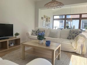 a living room with a white couch and a table at Centralt och mysigt boende i Tomelilla in Tomelilla