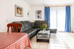 un salon avec un canapé et une table dans l'établissement Ferienhaus Nr 105, Kategorie Komfort, Feriendorf Hochbergle, Allgäu, à Karlsebene