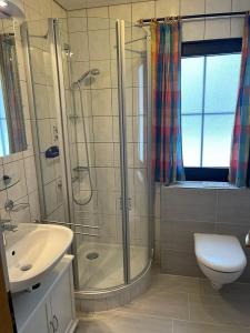 une salle de bains avec douche, toilettes et lavabo dans l'établissement Ferienhaus Nr 105, Kategorie Komfort, Feriendorf Hochbergle, Allgäu, à Karlsebene 11 autres photos