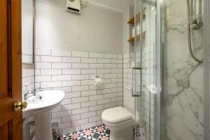 un bagno con doccia, WC e lavandino di Stable Cottage by Roslin Glen a Roslin