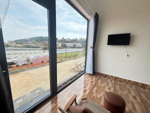 Il comprend un salon doté d'une grande fenêtre et d'une télévision à écran plat. dans l'établissement Villa Healing Home Hồ Bơi Nước Nóng, à Trai Mat