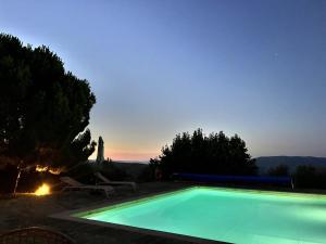 a swimming pool with a sunset in the background at Quinta Alto da Fraga in Vila Nova de Foz Coa