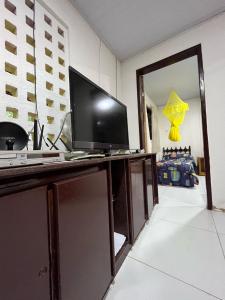a television on a desk in a room at Casa Simples e Charmosa na Praia de Ipioca in Maceió