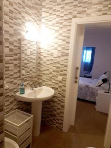 Un baño con lavabo y un dormitorio con cama. en Beach House Arinaga, en Arinaga 16 fotos más