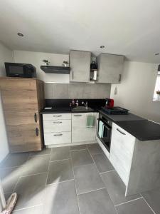 a kitchen with white cabinets and a black counter top at Warm home in Madonne-et-Lamarey