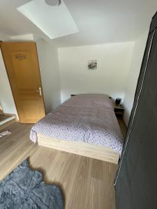 a small bedroom with a bed and a wooden door at Warm home in Madonne-et-Lamarey
