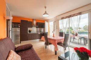 Saint-Simon-de-BordesにあるSaintesのテーブルと椅子のあるキッチンとリビングルーム