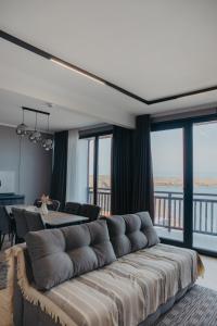 a living room with a large couch and a table at Апарт-отель Tong Marina in Tong