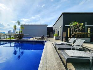 a swimming pool with lounge chairs next to a building at Skyview Bukit Bintang Fairlane Residence #24 in Kuala Lumpur
