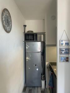 a kitchen with a refrigerator with a microwave on top of it at Appartement avec vue sur la mer in Six-Fours-les-Plages
