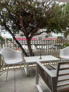una mesa y sillas en un balcón con un árbol en Via Mille House - new trilocale Riccione - centro, en Riccione