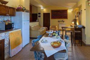 a kitchen and living room with a table and chairs at L' Etna di Gianlelè in Fleri