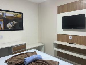 a room with a bed and a flat screen tv at Hotel Lucena in Guarabira +4 photos