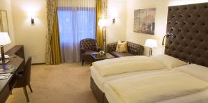 una camera d'albergo con letto, scrivania e sedia di Hotel Friesacher ad Anif