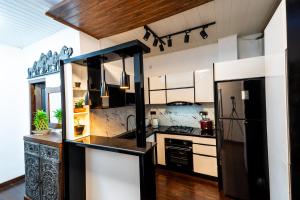 a kitchen with black and white appliances and a refrigerator at Golden stars hotel Dambulla in Dambulla