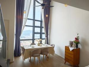 a dining room with a table and a large window at Urban Loft MRT Convenience KLCC Nearby in EKO CHERAS in Kuala Lumpur