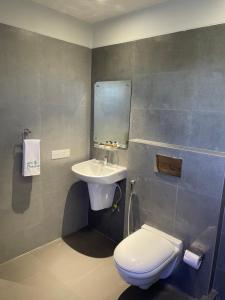 a bathroom with a toilet and a sink at Hotel The Crest in Kolkata
