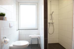 a bathroom with a shower and a toilet and a window at Deichhaus vorne in Norden