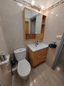 a bathroom with a toilet and a sink and a mirror at Tout près de la plage in Puerto de Sagunto +34 photos
