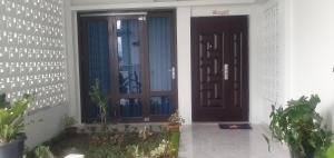 a pair of doors on a house with plants at Daeng Homestay in Pangururan