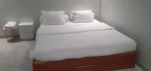 a bed with white sheets and pillows in a room at Daeng Homestay in Pangururan
