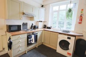a kitchen with a washing machine and a washer at Two bedroom flat in St Michael's Hill in Bristol
