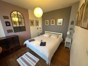 Ένα ή περισσότερα κρεβάτια σε δωμάτιο στο Rouen ECO LODGES maison entière avec terrasse dans jardin potager piscine parking
