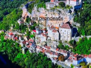 una ciudad al lado de una montaña en Les pirondeaux, en Rocamadour