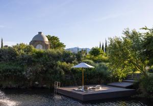 a table with an umbrella in the middle of a river at Oakvale Estate in Franschhoek
