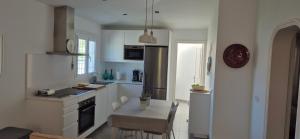 a white kitchen with a table and a dining room at HANDICAP 7 Bungalow 4 in San Bartolomé