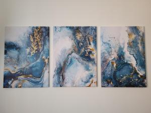 three paintings on a wall in a room at Casa Bei Sogni in Basiglio