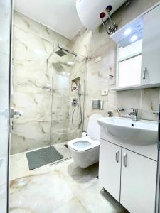 Un baño con ducha, inodoro y lavabo. en Centrum Hotel, en Tirana