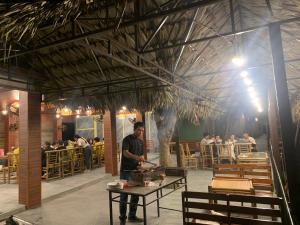 a man standing at a table in a restaurant at Trang An river mountain ecolodge Ninh Binh in Ninh Binh