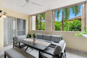 ein Esszimmer mit Tisch und Stühlen und Fenstern in der Unterkunft 2BR The Lakes Resort Escape, 4 Pools 5 min Airport in Cairns North
