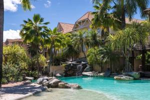 einen Pool vor einem Haus mit Palmen in der Unterkunft 2BR The Lakes Resort Escape, 4 Pools 5 min Airport in Cairns North