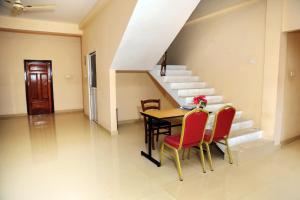 a dining room with a table and chairs and stairs at Jaffna Casa in Jaffna