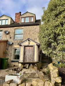 a wooden bird house in front of a house at Valley View Cottage by MaisonPro in Ebley