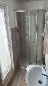 Un baño con ducha y lavabo blanco. en suite attico Acqua marina, en Porto Cesareo 4 fotos más